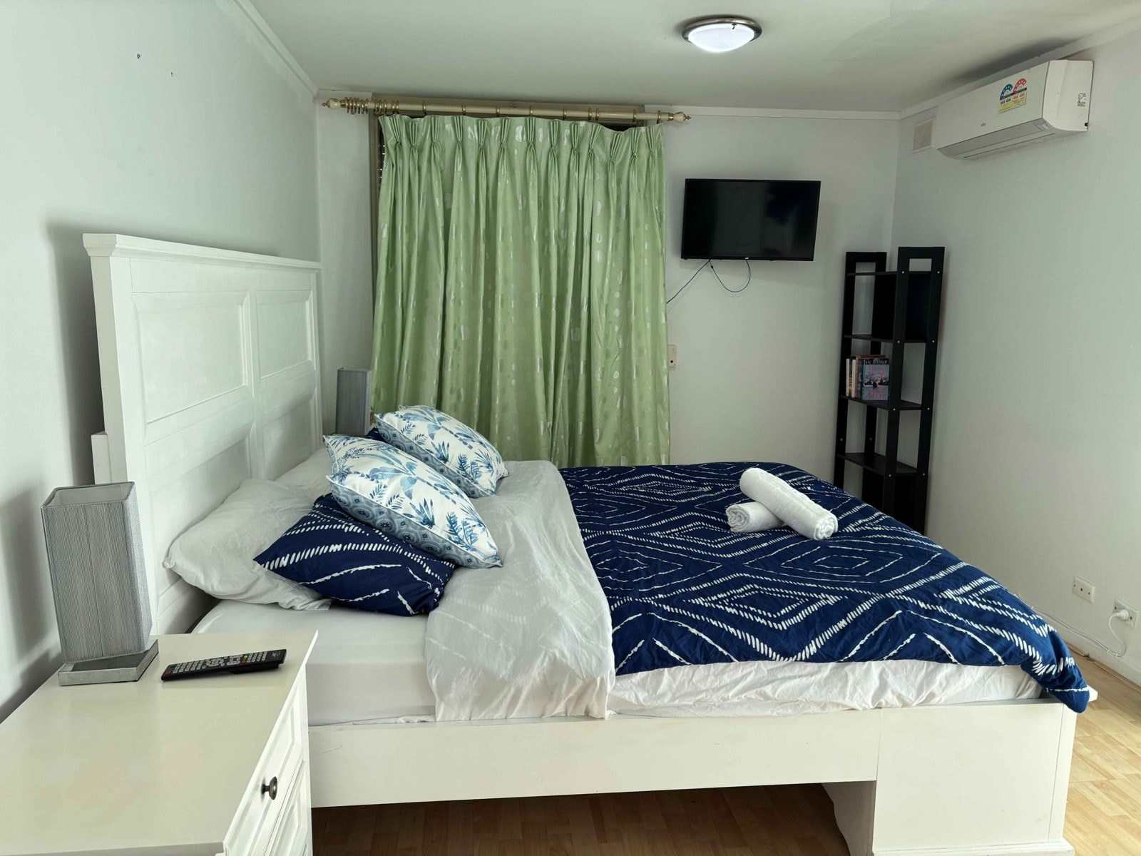Bedroom of a CISP SIL home with a double bed, curtains and reverse-cycle air conditioning