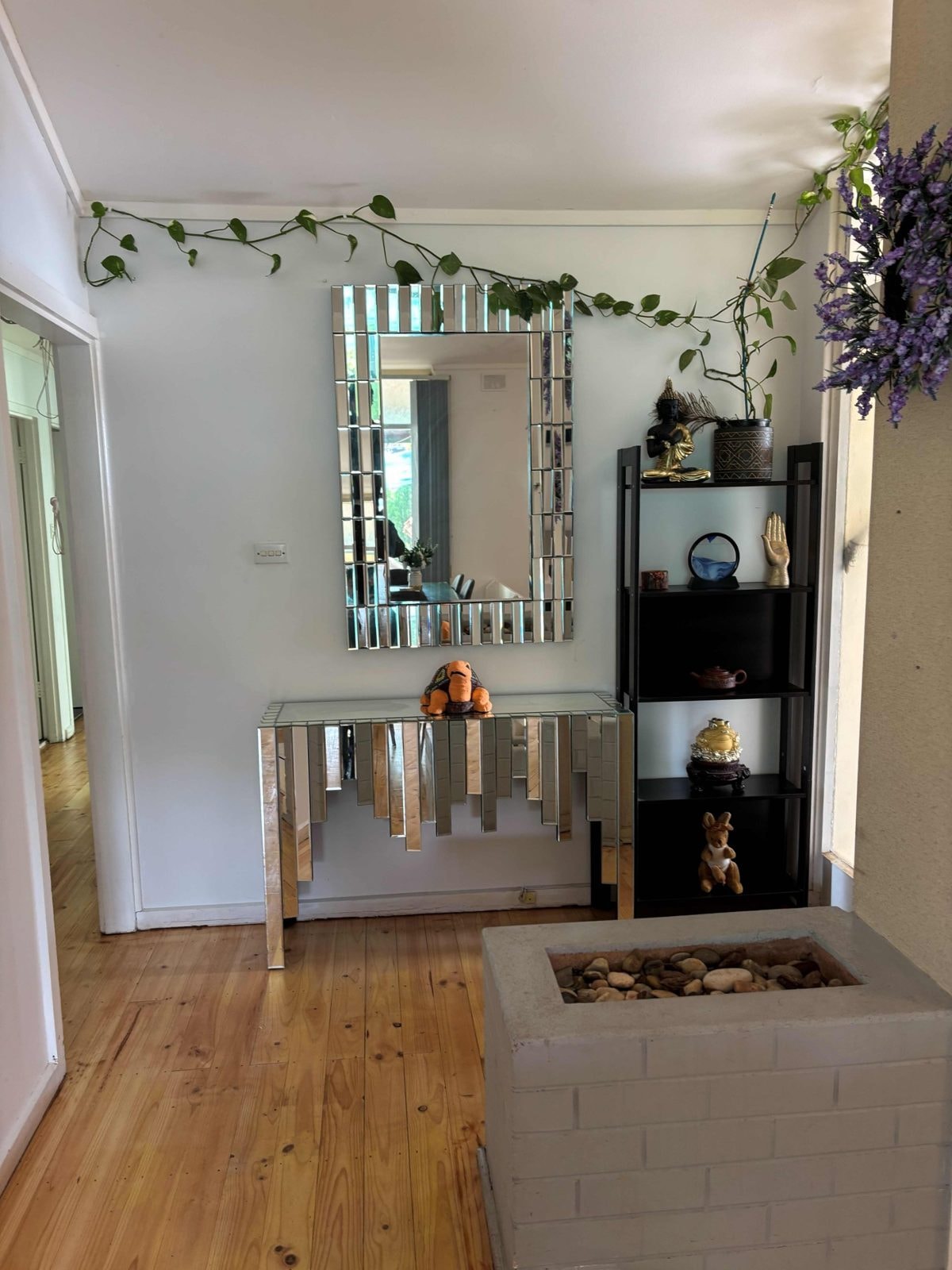 Entry hallway of a CISP SIL home with a mirrored console table and timber flooring