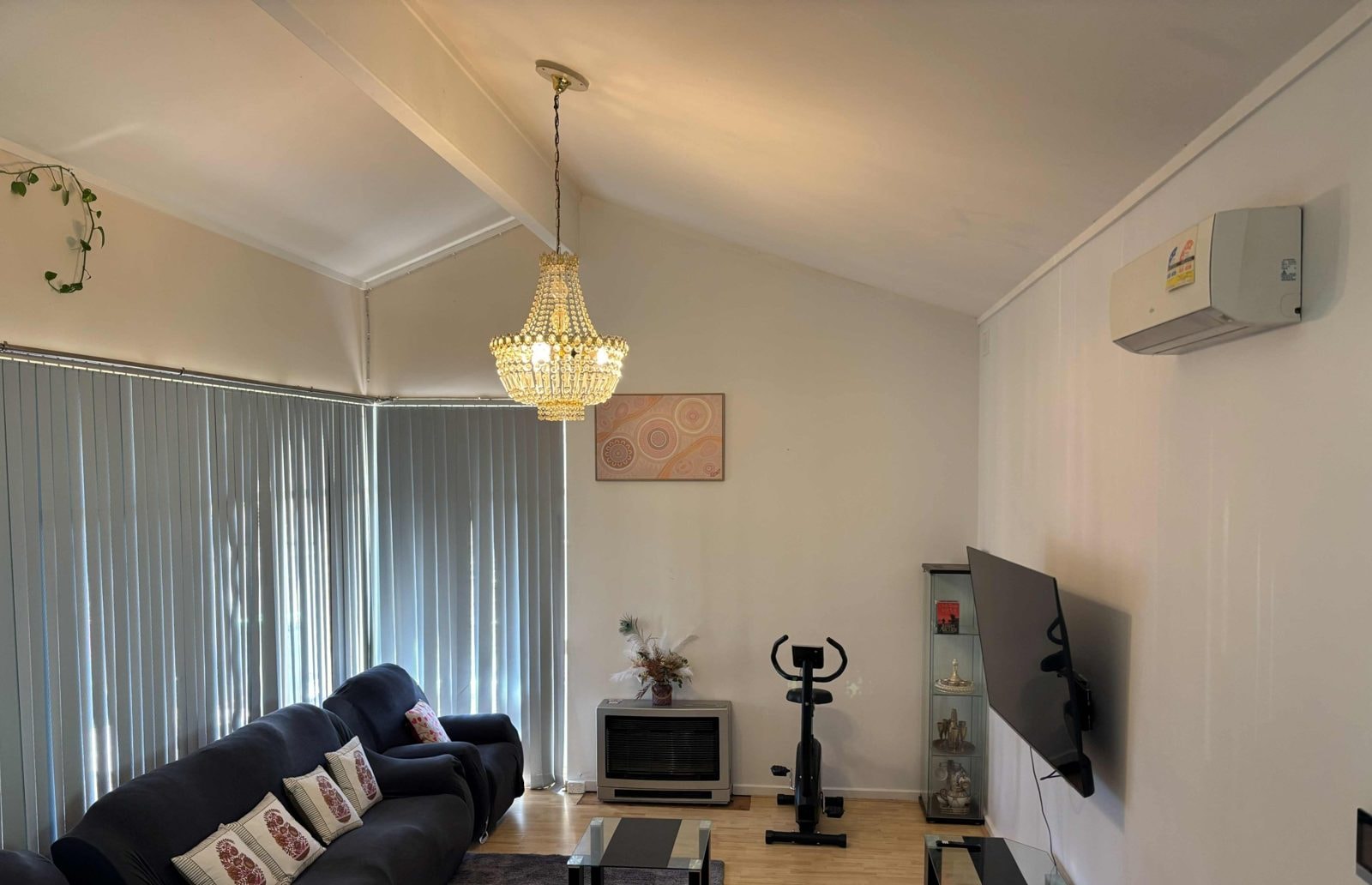 Living room of a CISP SIL home with lounge suites, chandelier and television